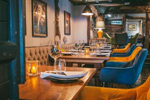 um restaurante com mesas de madeira e cadeiras com copos de vinho em Rose & Crown Inn em Knutsford
