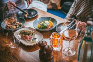 Rose & Crown Inn في كنوتسفورد: طاولة مع أطباق من الطعام وكؤوس من النبيذ