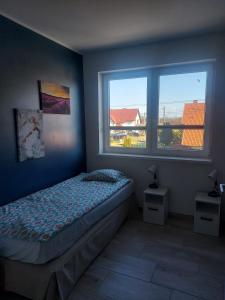 a bedroom with a bed and a large window at Siedlisko na Zaciszu Gościniec in Kąty Rybackie