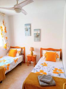 1 Schlafzimmer mit 2 Betten und orangefarbenen Kissen in der Unterkunft Molino Blanco Penthouse 15 in Playas de Orihuela