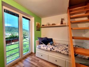 - une chambre avec des lits superposés et une grande fenêtre dans l'établissement GARTNAR HOME -Hiška s pridihom domačnosti in pogledom na hribe., à Radovljica