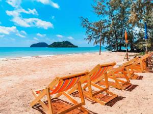 a row of chairs sitting on a beach at TK Beach Resort Koh Mak in Ko Mak
