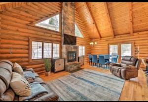 een woonkamer met een bank en een open haard in een blokhut bij 4 Bedroom Cabin in Summit Park, close to Park City in Park City