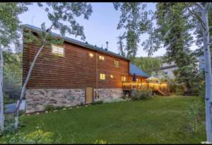 een groot houten huis met een stenen muur bij 4 Bedroom Cabin in Summit Park, close to Park City in Park City