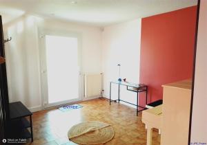 a living room with red walls and a tile floor at LA BOUVIERE in Aulnat