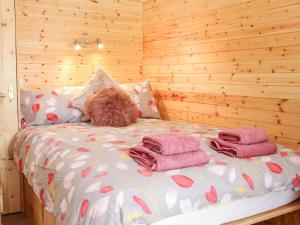 Una cama con toallas y un osito de peluche. en Acksea Holiday Lodges, en Kinnerley