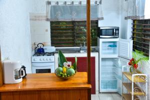 a kitchen with a bowl of fruit on a counter at Lighthouse Inn 2 in Negril