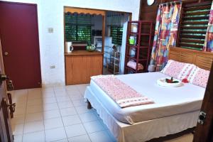 a bedroom with a large bed and a kitchen at Lighthouse Inn 2 in Negril