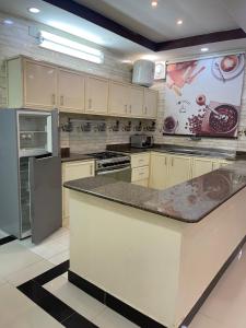 a kitchen with white cabinets and a counter top at شاليهات حميدانة الخير in At Turbīyah