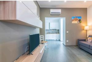 een woonkamer met een bank en een tv bij La casa di Alessandro in Noto