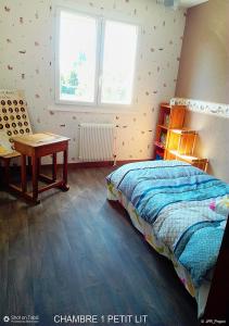 a bedroom with a bed and a desk and a table at LA BOUVIERE in Aulnat