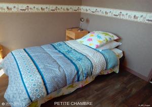 LA BOUVIERE في Aulnat: سرير مع لحاف أزرق في غرفة النوم