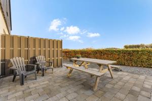 a picnic table and two chairs on a patio at Doornvlak - dicht bij strand en duinen! in Castricum