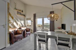 a living room with a table and leather chairs at Doornvlak - dicht bij strand en duinen! in Castricum