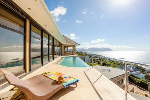 a house with a balcony with a swimming pool at Aqua Terra Boutique Guesthouse in Simonʼs Town