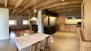 eine große Küche mit einem weißen Tisch und Stühlen in der Unterkunft Brasel in La Brévine