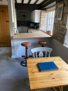 a kitchen with two stools and a wooden table at Flat 2 - The Old Mill - Bowbridge Lock - Stroud in Stroud