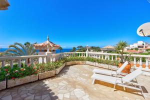un patio con una valla blanca y un banco en Luxury villa El Duque Ocean View en Adeje