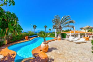 a swimming pool with a potted plant in a yard at Luxury villa El Duque Ocean View in Adeje