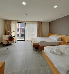 um quarto de hotel com duas camas e um sofá em Sunny homestay PhuQuoc em Phu Quoc