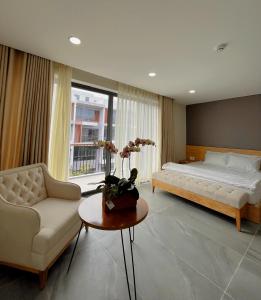 um quarto com uma cama, um sofá e uma mesa em Sunny homestay PhuQuoc em Phu Quoc