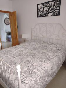1 dormitorio con 1 cama blanca con marco de cama blanco en La Casa Arboleas, en Arboleas