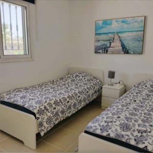 1 dormitorio con 2 camas y una foto en la pared en La Casa Arboleas, en Arboleas