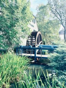 uma ponte azul sobre um lago num jardim em Apartment im Gästehaus Matzmühle Ruhland (6-8 P.) em Ruhland