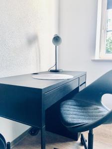 a desk with a chair and a lamp on it at Apartment im Gästehaus Matzmühle Ruhland (6-8 P.) in Ruhland