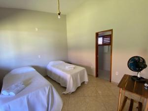 a room with two beds and a table in it at Takito Kite House, Praia da Baleia, Itapipoca CE in Franco