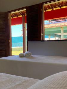 a bedroom with a bed with two towels on it at Takito Kite House, Praia da Baleia, Itapipoca CE in Franco