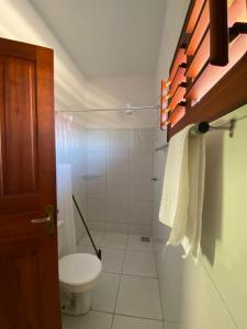 a white bathroom with a toilet and a shower at Takito Kite House, Praia da Baleia, Itapipoca CE in Franco