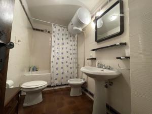 een badkamer met een wastafel, een toilet en een spiegel bij 044 Trilocale, Pinzolo in Pinzolo