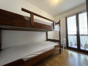 een slaapkamer met 2 stapelbedden en een raam bij 044 Trilocale, Pinzolo in Pinzolo