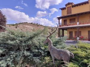 a statue of a deer in front of a building at Hotel Milagros Rio Riaza in Milagros
