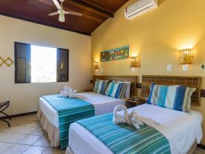 Habitación de hotel con 2 camas y toallas. en Pousada Praia das Ondas - Pé na areia, en Itacimirim