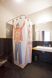 Ein Mann in einem Duschvorhang im Bad in der Unterkunft Schillinger-Berlin - dance, sleep, repeat! in Berlin