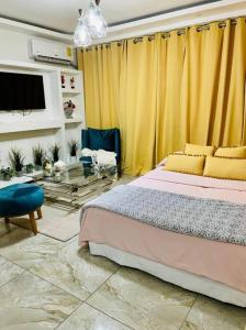 a bedroom with a bed and a yellow curtain at Romantic Studio w/Jacuzzi 15 min Airport in Ensanche Los Minas
