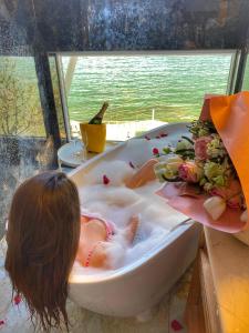 una niñita acostada en una bañera en Sea&Sky Villa Costinesti, en Costinesti