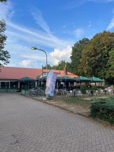 a building with tables and chairs and a street light at Stacaravan 85 Recreatiepark De Tien Heugten. in Schoonloo