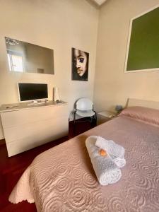 een slaapkamer met een bed en een televisie bij A Casa di Mau in Palermo