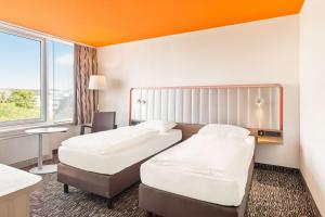 a hotel room with two beds and a window at Park Inn by Radisson Dresden in Dresden