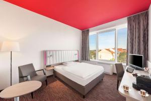 a hotel room with a bed and a desk with a computer at Park Inn by Radisson Dresden in Dresden