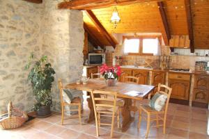 eine Küche mit einem Holztisch und Stühlen in der Unterkunft Gite Le Clos de Lumière in La Roche-des-Arnauds