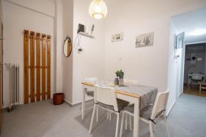 uma sala de jantar com uma mesa e cadeiras brancas em Metaxourgeio metro st. 2 bedrms 4 pers. apartment. em Atenas