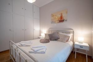 um quarto com uma cama branca e toalhas em Metaxourgeio metro st. 2 bedrms 4 pers. apartment. em Atenas