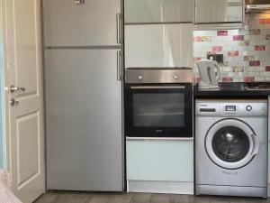 een keuken met een magnetron en een wasmachine bij X SUITE APART in Fethiye
