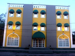 een geel gebouw met bogen en ramen bij Diviyum Manor in Port Blair