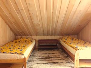 a room with two beds in a wooden room at Zakątek nad Sanem, Załuż 128 in Załuż