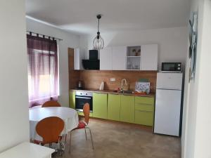 uma cozinha com uma mesa e um frigorífico branco em Spacious 2-bedroom apartment with terrace sea view em Zaboric